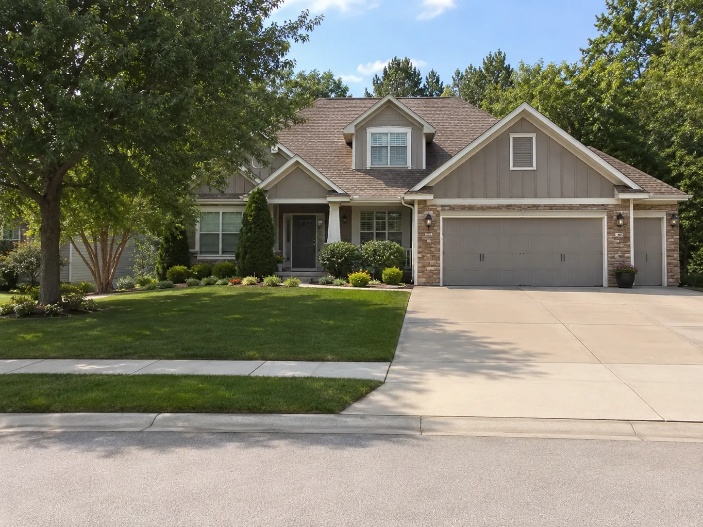 Residential home with a concrete driveway, lawn, and trees
