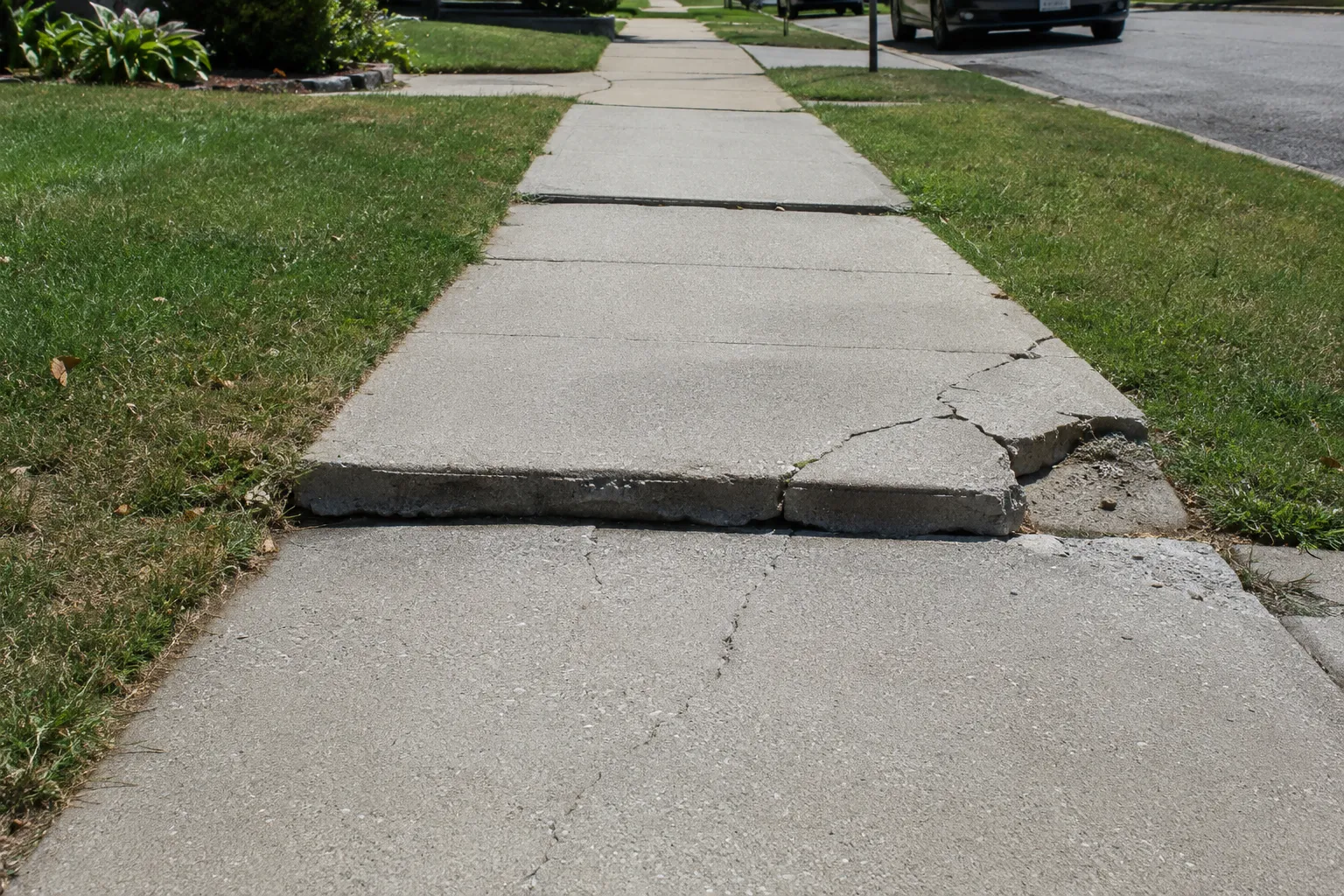 Raised and cracked concrete sidewalk panel